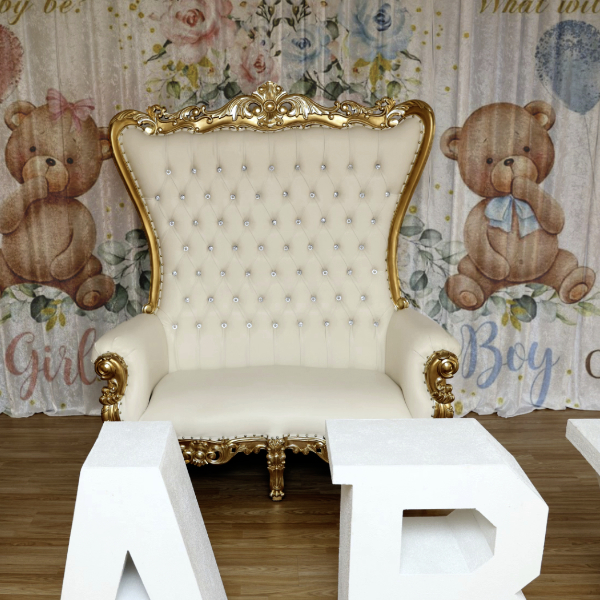 beautiful white throne chair in front of baby shower curtains