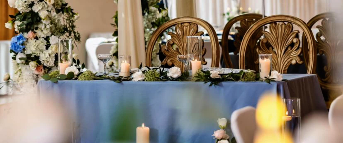 gorgeous table with ornate gold chairs candlelight and blue accents